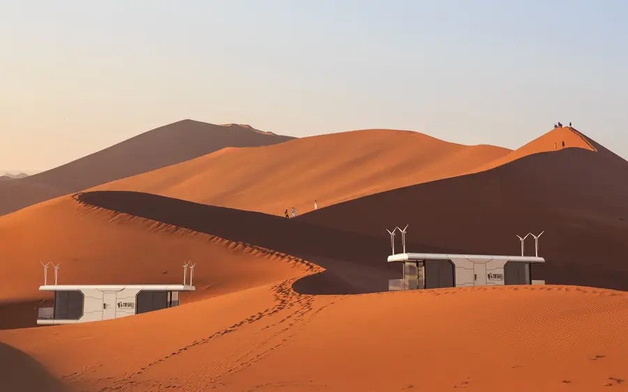 Cabins among orange desert dunes at dusk